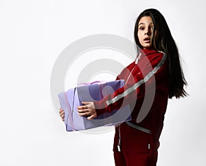 Caucasian preteen girl in tracksuit holding wrapped gift box portrait