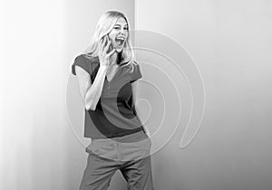 Cute surprised young woman chatting by mobile phone isolated background. Phone talking.