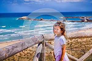 Cute sweet nice smart look brat little girl baby wink with colorful summer seascape background