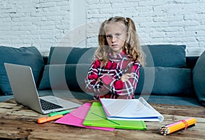 Cute sweet sad and overwhelmed blonde hair primary school girl looking angry bored and tired in stress with homework and studying