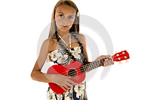 Cute tan girl wearing tropical dress playing ukulele
