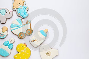 Cute tasty cookies of different shapes on white background, top view. Baby shower party