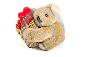 Cute teddy bear carrying bamboo basket full of red roses and heart