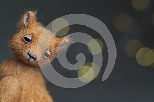 Cute teddy bear  on light background. Holiday glowing backdrop. Defocused background with blinking light