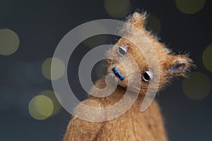 Cute teddy bear  on light background. Holiday glowing backdrop. Defocused background with blinking light