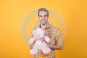 Cute teddy bear toy. Softness tenderness. Playful adult. Cute and romantic. Bearded hipster play toy yellow background