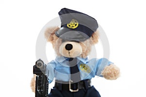 Cute teddy in policeman uniform holding gun isolated against white background