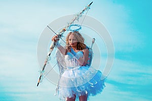 Cute teen cupid on the cloud - sky background. Lovely and cute youth. Lovely girl cupid with bow and arrow is ready to