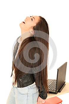 Cute teen girl by computer with her head back laughing