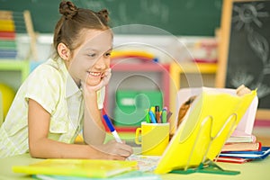 Cute teen girl doing homework in her room