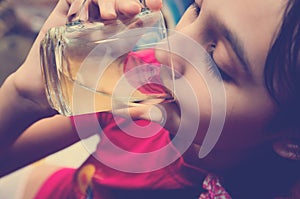 Cute teen girl drinks juice from a glass. Toning in the style of instagram
