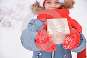 cute teen girl holding out a gift box, christmas present, outdoor in winter