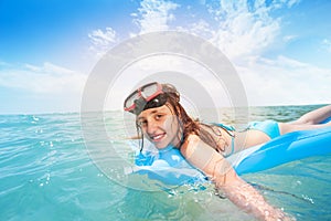 Cute teen girl snorkeling on matrass in the sea