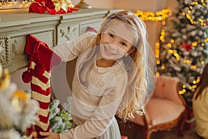 Cute teen girl taking present from Christmas socks