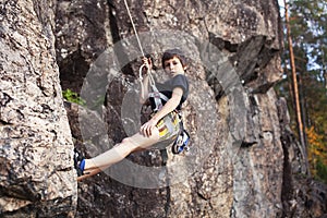 Cute teen kid climbing on rock with insurance, lifestyle sport people concept