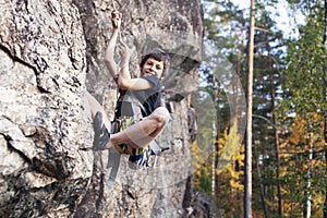 Cute teen kid climbing on rock with insurance, lifestyle sport people concept