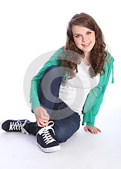 Cute teenage girl with blue eyes sits on floor