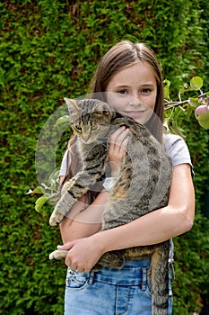 Cute teenage girl cuddles  with her cat photo