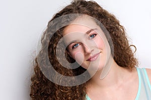 Cute teenage girl with curly hair smiling
