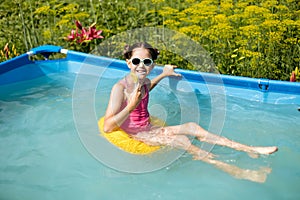 Cute teenage girl drinking a drink relaxing in the pool at the hotel