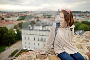 Cute teenage girl enjoying a view of Vilnius city from the Gediminas hill. Exploring tourist attractions with kids