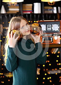 A cute teenage girl with golden balls in her face smiles cheerfully