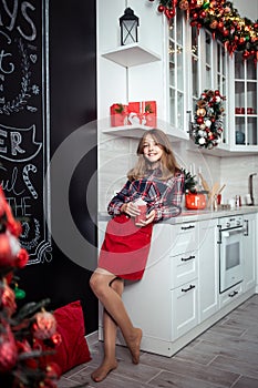 Cute teenage girl in the kitchen with Christmas decorations. The winter holidays.