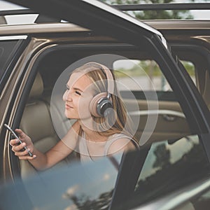 Cute teenage girl listening to her favorite music/audiobook on hig-end headphones