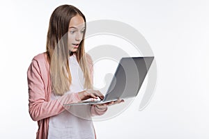 Cute teenage girl looking surprised while reading email