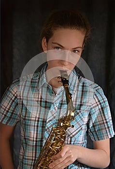 Cute teenage girl practicing saxophone