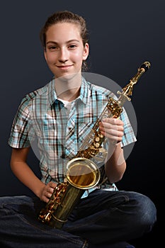 Cute teenage girl practicing saxophone photo