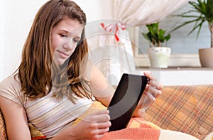 Cute teenage girl reading novels on ebook reader