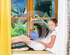 Cute teenage girl siiting on window siil