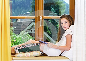 Cute teenage girl siiting on window siil