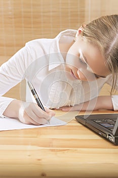 Cute Teenage Girl Writing Her Homework t the Table