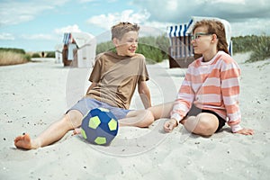 Cute teenage paar sitting on summer white beach at summer holidays