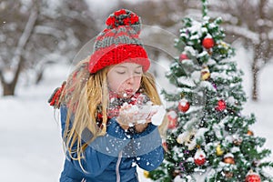 Cute teenager or girl decorating christmas tree outdoor