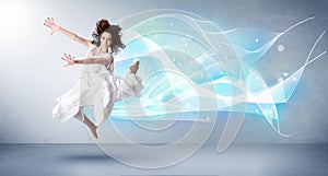 Cute teenager jumping with abstract blue scarf around her