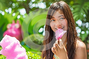 Cute Thai girl is eating pink candyfloss