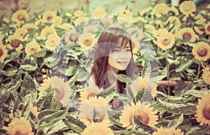 Cute Thai girl in the middle of beautiful sunflower field in vintage color