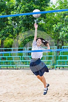 Cute Thai schoolgirl is playing beach volleyball in school