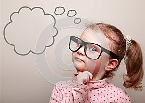 Cute thinking kid girl in glasses with empty bubble