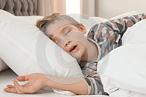 Cute tired boy sleeping in bed