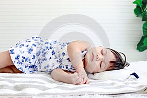 Cute toddle baby girl infant sleeping well on white bed and has sweet dream, beautiful sleepy daughter kid, little child sleeps in photo