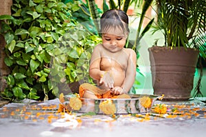 cute toddler baby boy bathing in decorated bathtub at outdoor from unique perspective
