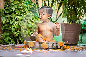 cute toddler baby boy bathing in decorated bathtub at outdoor from unique perspective