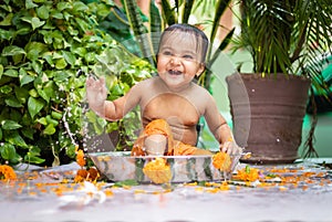 cute toddler baby boy bathing in decorated bathtub at outdoor from unique perspective