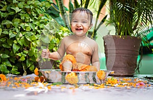 cute toddler baby boy bathing in decorated bathtub at outdoor from unique perspective