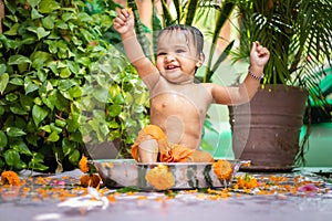 cute toddler baby boy bathing in decorated bathtub at outdoor from unique perspective