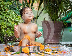 cute toddler baby boy bathing in decorated bathtub at outdoor from unique perspective